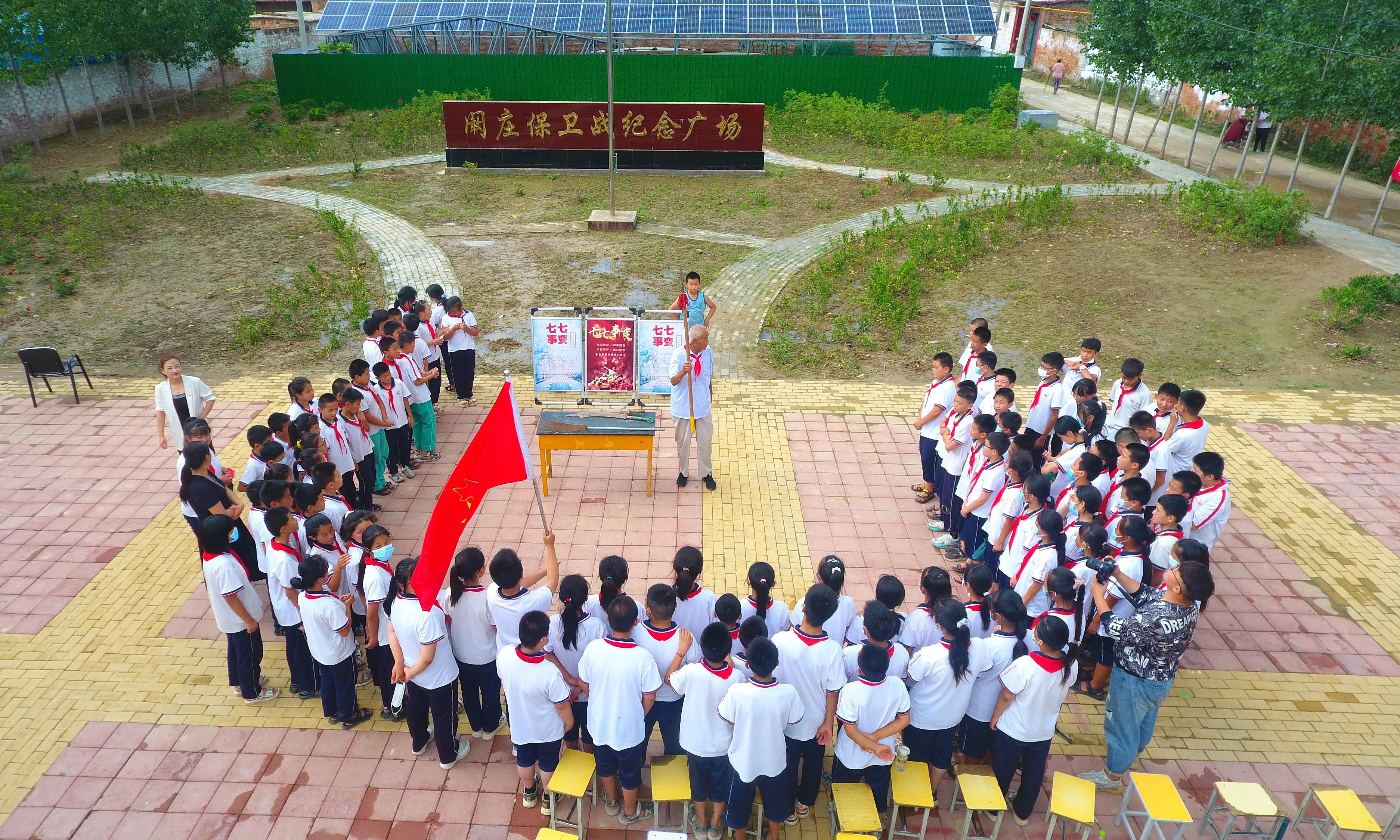 2022年7月6日，山東省聊城市，在茌平區(qū)菜屯鎮(zhèn)闞莊村的闞莊保衛(wèi)戰(zhàn)紀(jì)念廣場，闞莊保衛(wèi)戰(zhàn)親歷者王光木老人，為小學(xué)生們講述抗戰(zhàn)故事，展示大刀、長矛。